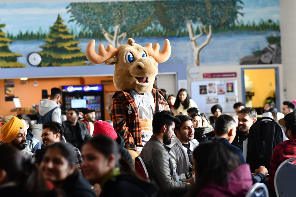 Group of 㽶Ƶ students with moose mascot in cafeteria